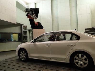 Beschuss eines Fahrzeugdachs durch einen Roboter.