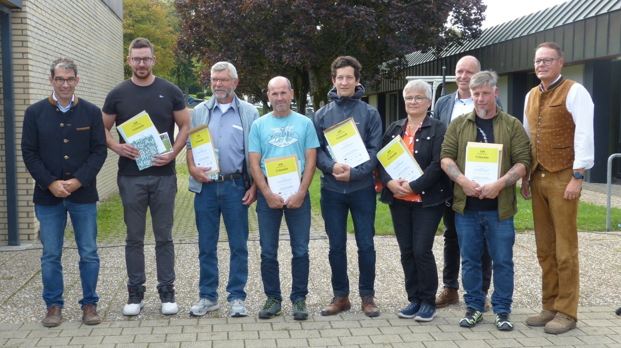 Gewinnerinnen und Gewinner der Ackerwildkraut-Meisterschaft 2025 und Landwirte aus dem Ackerwildkrautschutzprojekt Rangendingen gemeinsam mit Staatssekretär Dr. Andre Baumann und Regierungspräsident Klaus Tappeser stehen zusammen und lachen in die Kamera. 