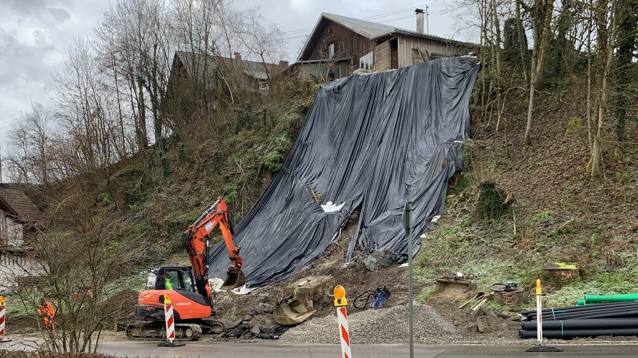 Das Foto zeigt eine Hang der mit Folie und einem Hebekran gesichert wird