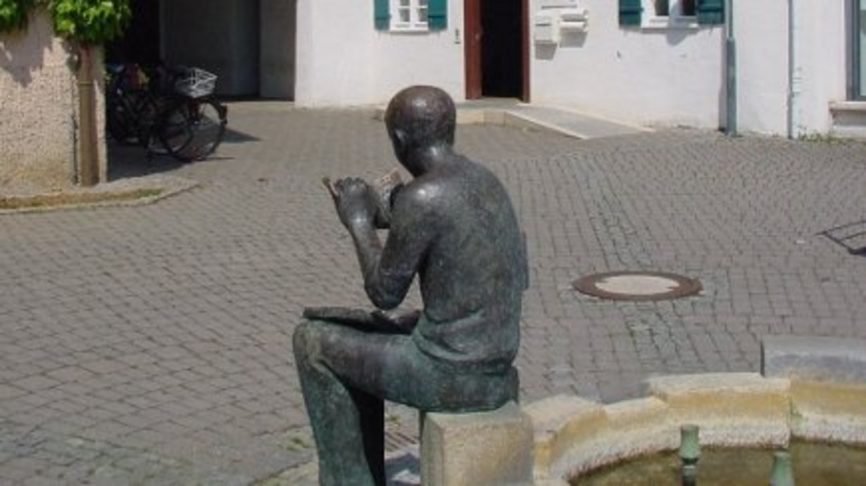 StadtBücherei im Pfleghof Langenau - Lesede Figur im Aussenbereich