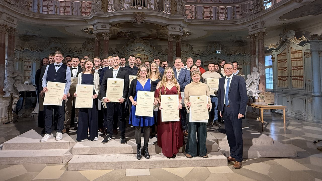 Das Foto zeigt ein Gruppenbild der neuen Meisterinnen und Meister im Beruf Landwirt/in gemeinsam mit Regierungspräsident Klaus Tappeser im Bibliotheksaal des Klosters Bad Schussenried