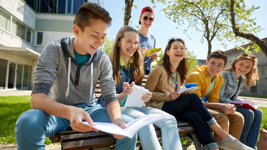Schülerinnen und Schüler in der Pause Schülerinnen und Schüler in der Pause, lachend auf einer Bank