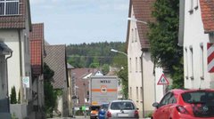 LKW und Autos auf einer Straße durch einen Ort