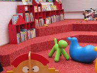 Rote Sitzstufenlandschaft mit Bilderbuchtrögen in der Kinderbücherei der Stadtbücherei Albstadt-Ebingen