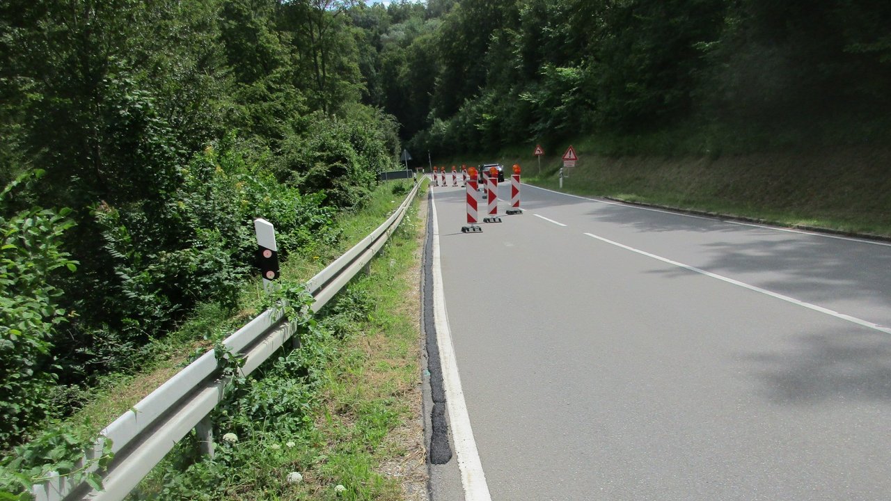 Das Foto zeigt einen teilweise abgesperrten Abschnitt der Eninger Steige in einem Waldstück