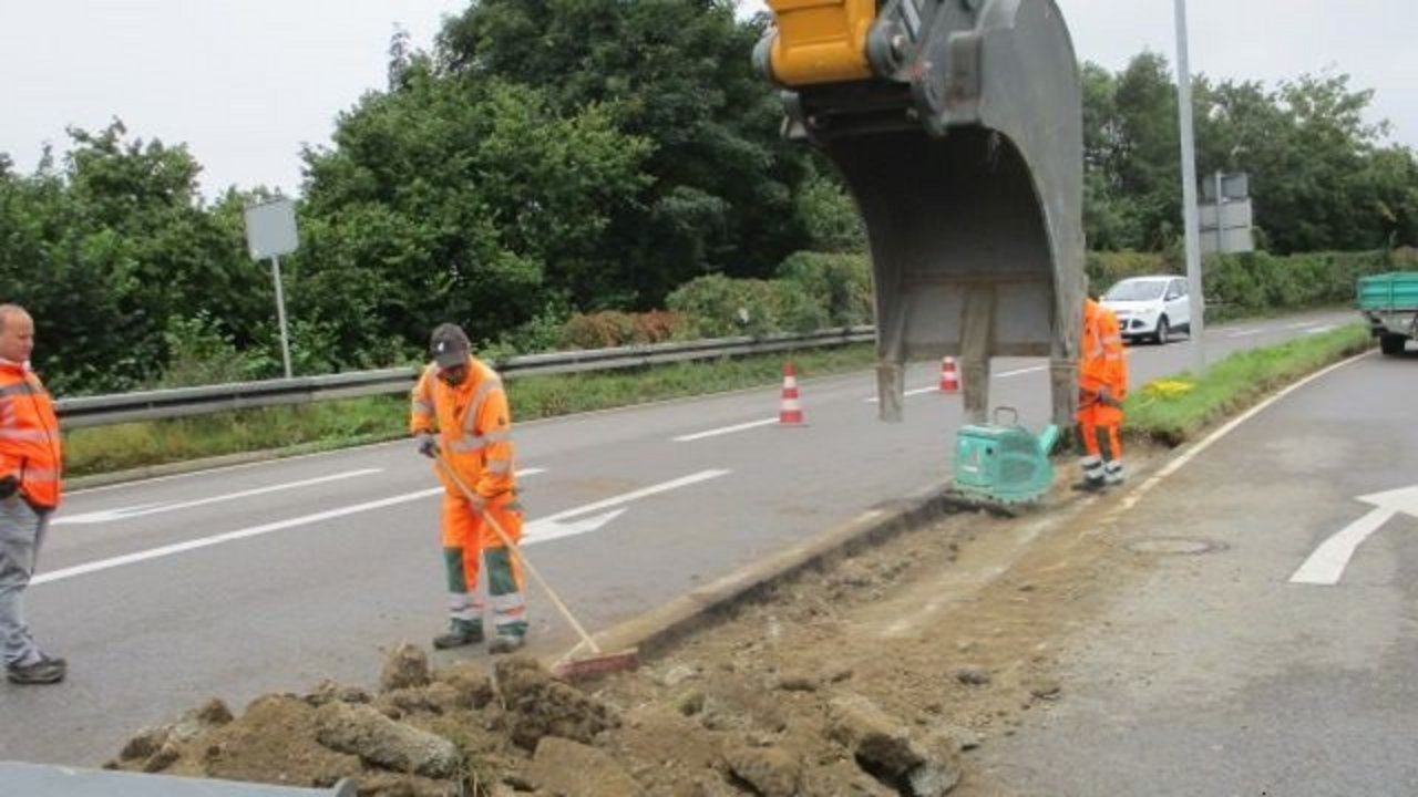Vorarbeiten für die Instandsetzung der Lärmschutzwand beim Schussentalviadukt; Ein Bagger gräbt auf der rechten Seite die Straße auf