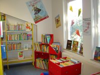 Kinderecke mit roten Bilderbuchtrögen in der Stadtbücherei Albstadt - Zweigstelle Onstmettingen