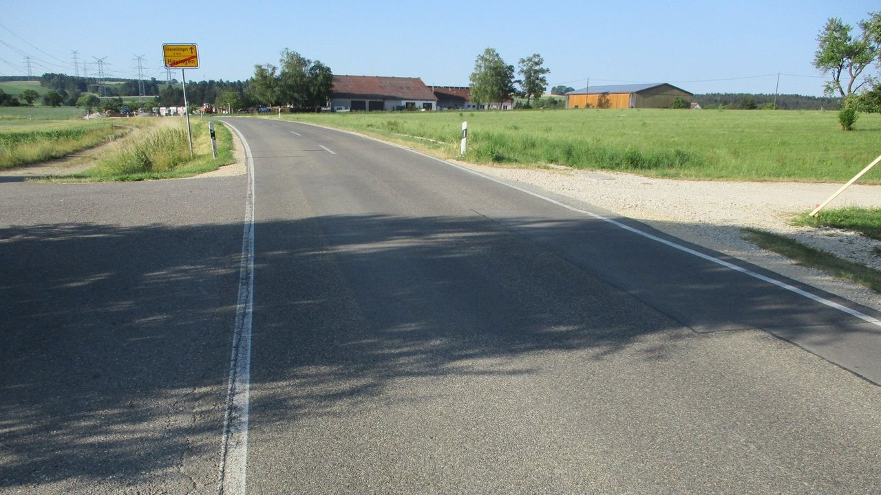 Das Foto zeigt die L 249 in Richtung Oberwilzinge; links und rechts Wiesen; im Hintergrund eine Ortschaft