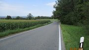 Eine Straße neben einem Feld