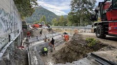 Bauarbeiten an einer Brücke. Der Überbau ist abgerissen, mehrere Arbeiter sind an den Widerlagern der Brücke zugange.