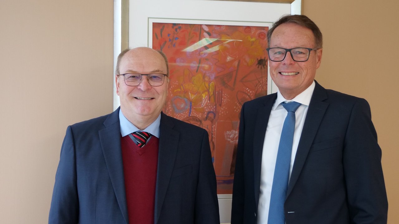 Das Foto zeigt Andreas Eytner und Regierungspräsident Klaus Tappeser stehend vor einem Bild