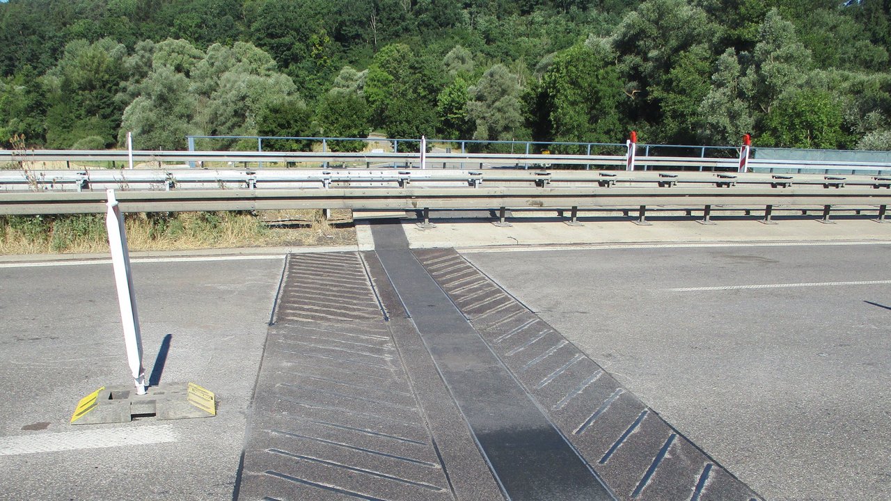Das Foto zeigt die neue Übergangskonstruktion auf der Brücke über die Wiesaz bei Dußlingen in Fahrtrichtung Tübingen. Im Bildhintergrund sind Bäume zu erkennen.