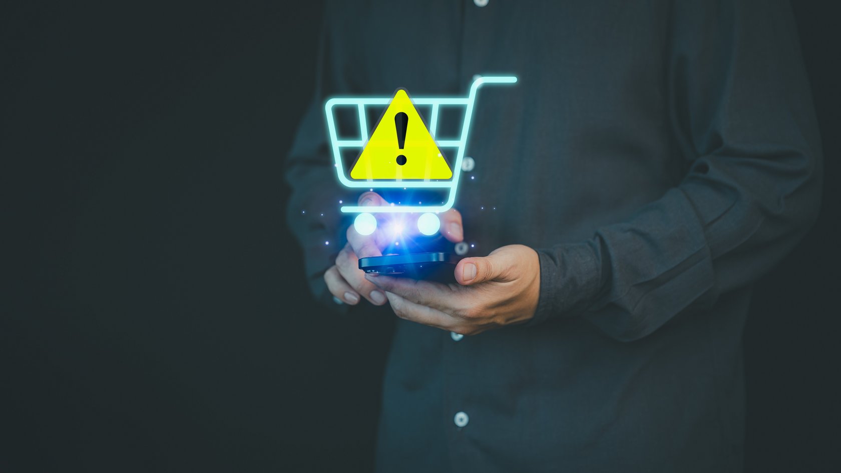 Eine Hand hält einen kleinen Einkaufswagen in der Hand, darüber ist eine Warnzeichen gezogen.