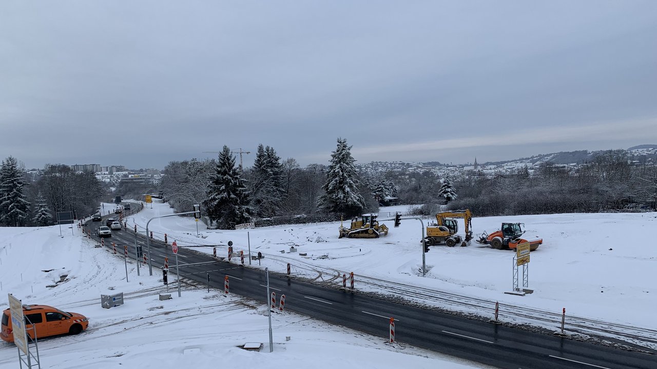 Das Bild zeigt die Umbauarbeiten am Anschluss Rottenburg-Kiebingen; mehrere Baustellenfahrzeuge; alles ist mit Schnee bedeckt