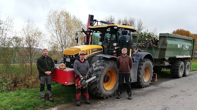 Bild zeigt Traktor und Mitarbeiter