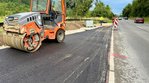 Eine neu asphaltierte Fläche, die direkt an eine Straße anschließt.