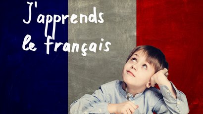 Junge schuat zum Schriftzug Jápprends le francias