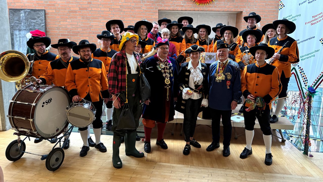 Narrenempfang 2025 im RP Tübingen - Gruppenbild Das Foto zeigt Regierungspräsident Klaus Tappeser, Ministerin Dr. Nicole Hoffmeister-Kraut und Roland Wehrle mit einer Narrenkapelle
