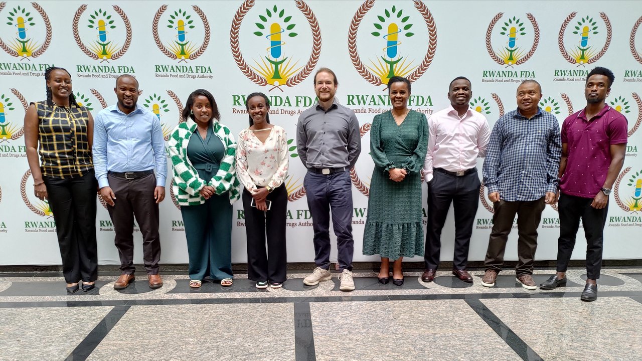 Das Bild zeigt ein Gruppenbild vor einer Pressewand in Ruanda mit teilnehmenden Inspektoren und Inspektorinnen der R-FDA 