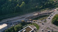 Ein Luftbild einer Straßenkreuzung. Neben der Kreuzung ist ein Einschnitt in einen Hang erkennbar, auf dem Straßenbauarbeiten stattfinden.