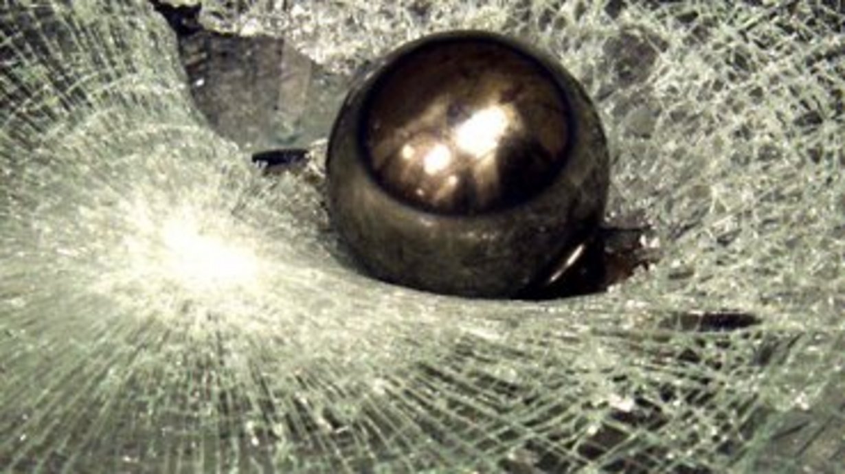 Einschlag bei einem Durchwurf; man sieht eine Kugel und geborstenes Glas