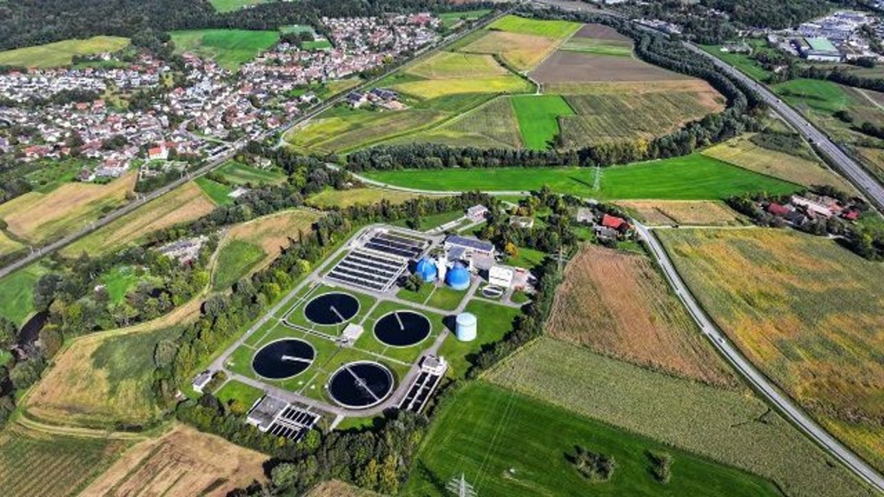 Das Foto zeigt die Kläranlage Langwiese von oben. Im Hintergrund sieht man Häuser, Wiesen und Wälder