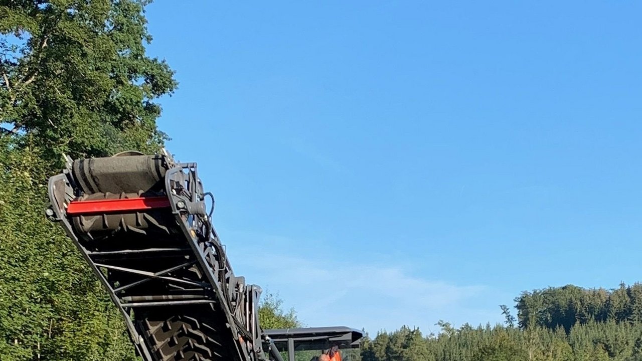 Das Bild zeigt die Baustelle an der B 312; mehrere Baustellenfahrzeuge und Bauarbeiter und die aufgerissene Straße