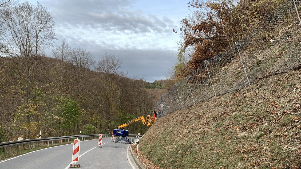 Das Bild zeigt die Talheimer Steige an der gerade Arbeiten mit einem Hangsicherungsgerät durchgeführt werden. Anbringen von Ösenankerzäunen
