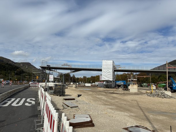 Foto einer Baustelle. Eine halbe Brücke verläuft von rechts im Bild ansteigens zur Mitte hin und endet über einer Straße. 
