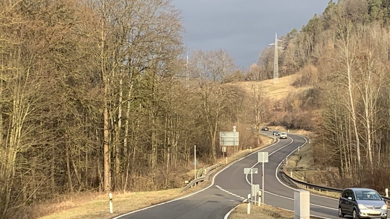 Eine Landstraße verläuft über eine Brücke durch eine spätherbstliche Landschaft auf der Schwäbischen Alb. 
