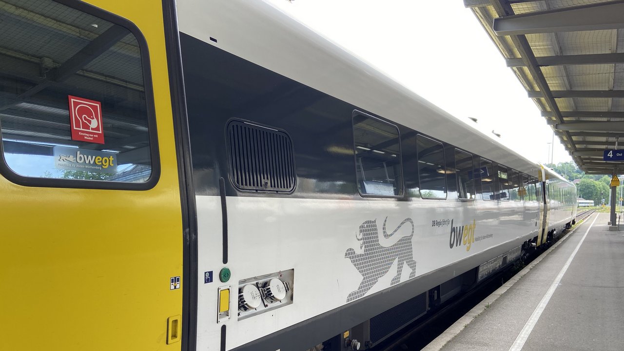 Gelb-schwarzer Wagon des Nahverkehrs steht in einem Bahnhof
