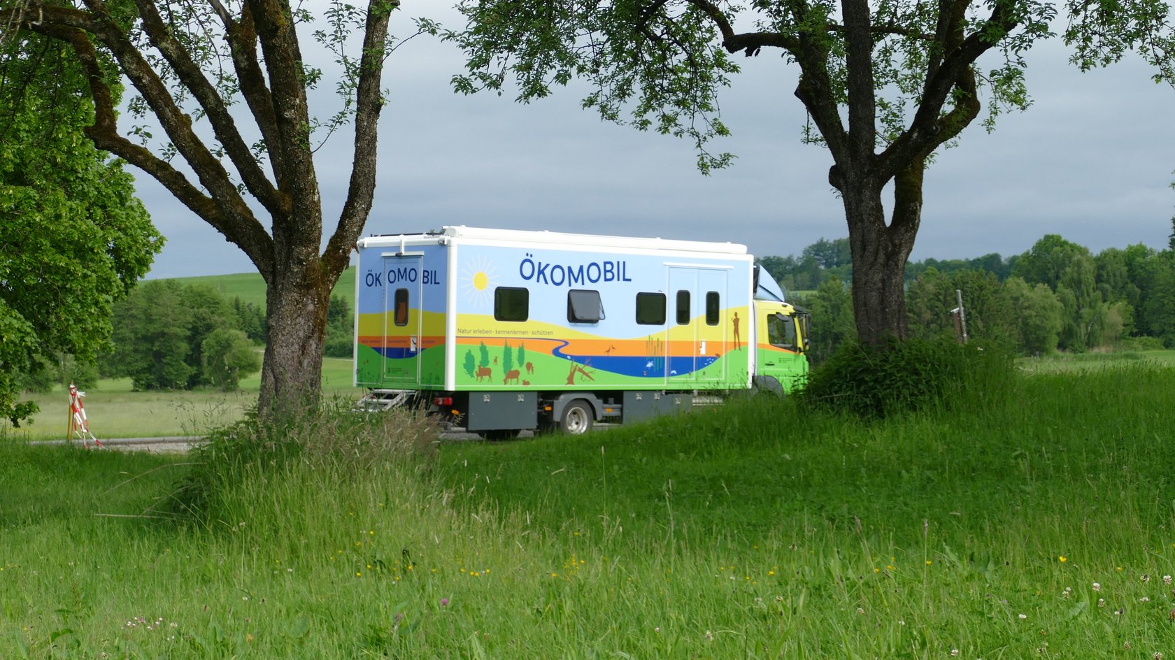 Das Ökomobil (Laster) fährt durch die Landschaft