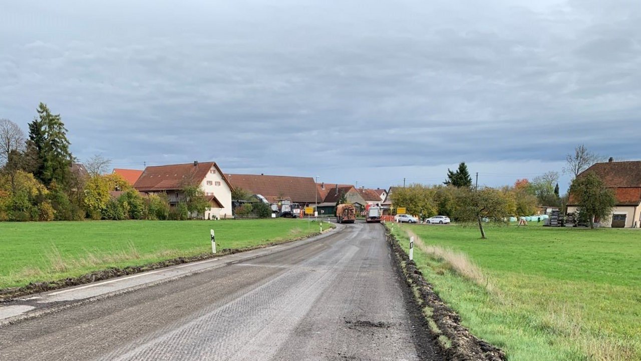 Blick auf die Fahrbahn der B 312 zwischen Hohenstein und Bernloch-Huldstetten; links und rechts grüne Wiesen; im Hintergrund eine Ortschaft