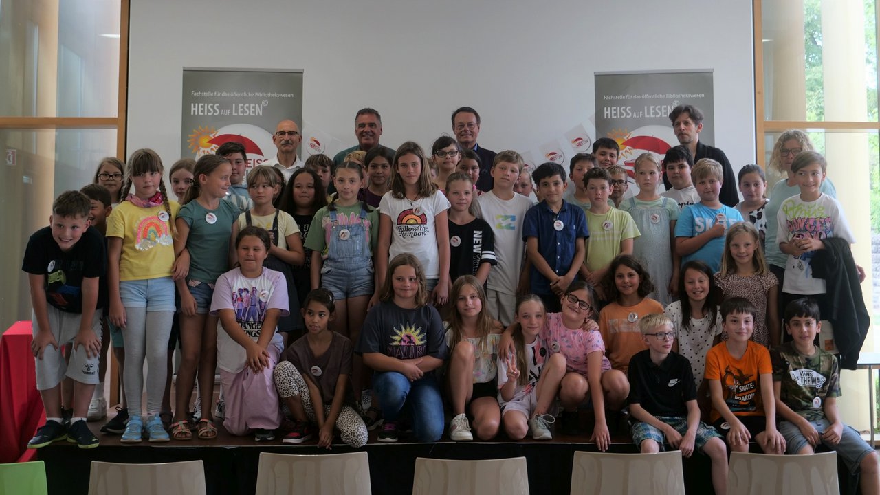 Gruppenbild mit mehreren Schülern, Herrn Klaus Tappeser (Regierungspräsident), Herr Hölsch (Bürgermeister der Gemeinde Dußlingen und Herrn Jürgen Blim (Leiter der Fachstelle für das öffentliche Bibliothekswesen
