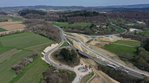 Eine Straßenbaustelle mit einer provisorischen Umfahrung, die neben einer Brücke aufgeschüttet wurde.