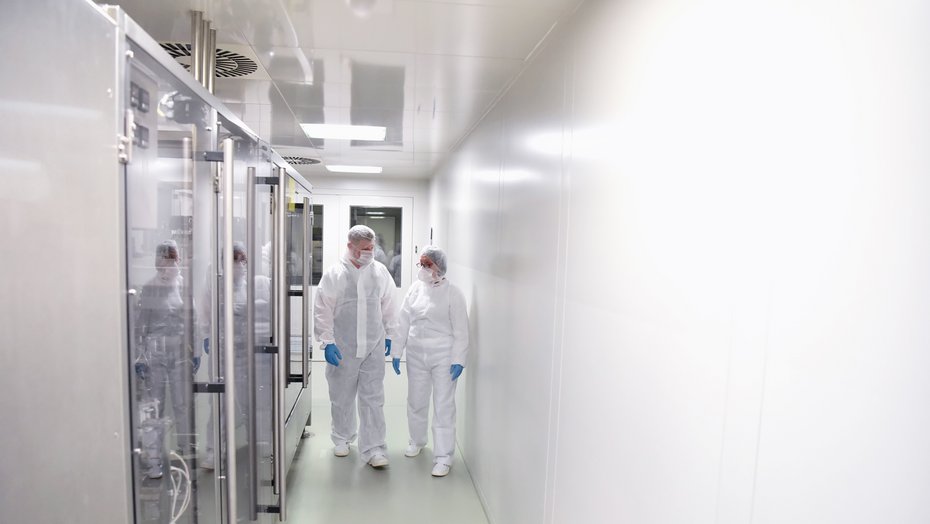 Zwei Kontrolleure im Reinraum des Labors Zwei Kontrolleure im Reinraum des Labors