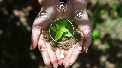 Ene Frauenhand hält Erde in der Hand, darüber sind Symbole eingebledent, die auf die Lebensgrundlagen Boden, Wasser, Luft, erneuerbare Energien hinweisen