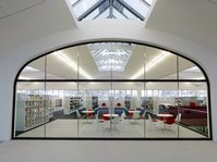 Blick durch die Scheibe auf das Lesecafé in der Stadtbücherei Mössingen in der Tonnenhalle im Pausa-Quartier