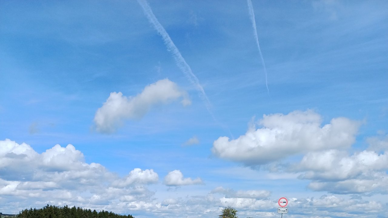 Das Foto zeigt den Radweg der an der B 27 bei Dotternhausen entlang führt. Links und rechts Wiesen und im Hintergrund mehrere Waldstücke. Rechts im Hintergrund die Burg Hohenzollen