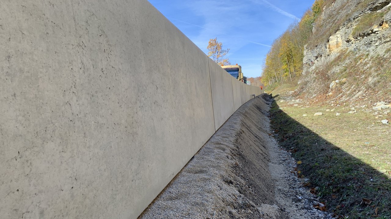 Das Foto zeigt eine Schwergewichtsmauer aus Betonfertigteilen zur Felssicherung an einem Hang.