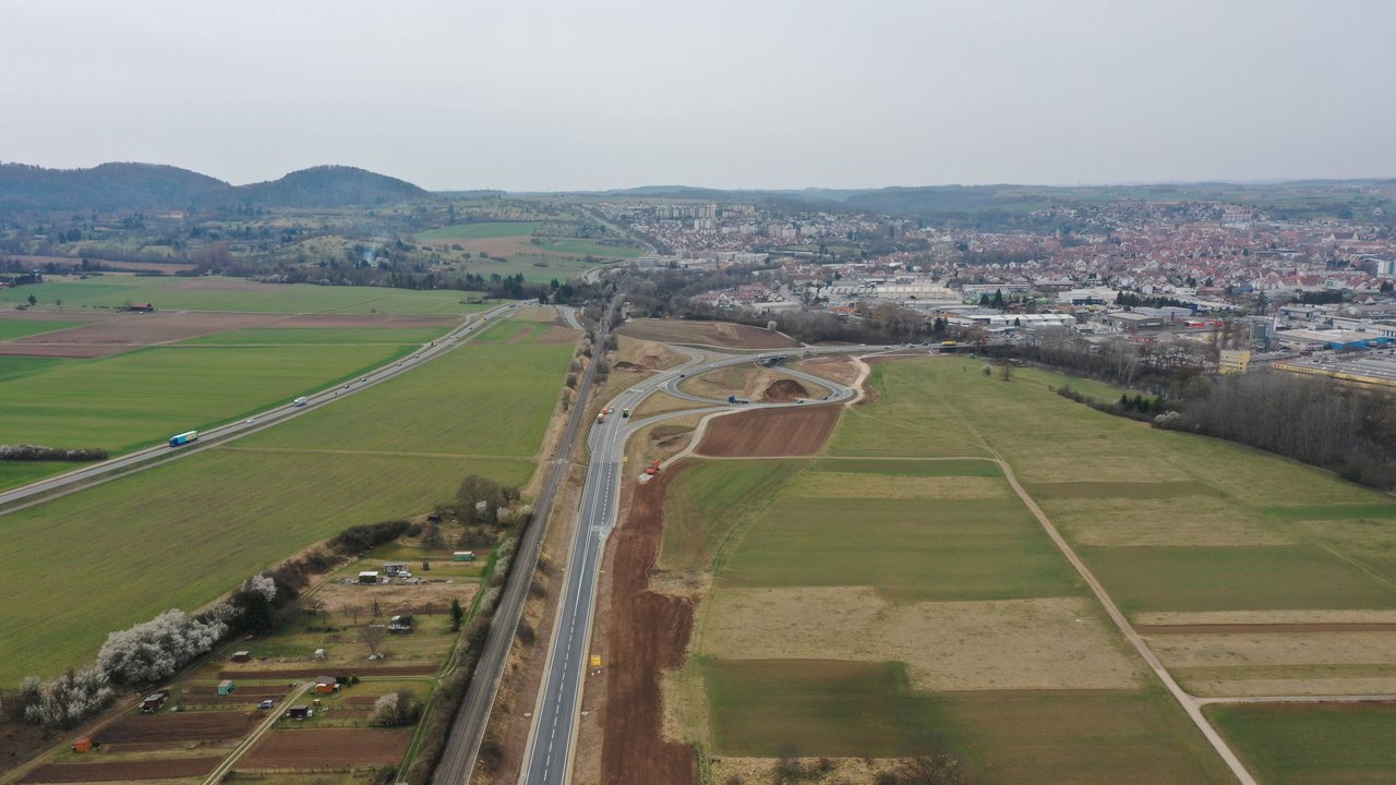 Luftbild der B 28 neu zwischen Tübingen Rottenburg; man sieht die B 28 und angrenzende Äcker, Wiesen und Felder und im Hintergrund Rottenburg