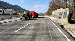Foto einer Straße, auf der kein Verkehr fließt. Der Straßenbelag und die Markeirungen sind neu, es befinden sich noch Baufahrzeuge auf der Straße.