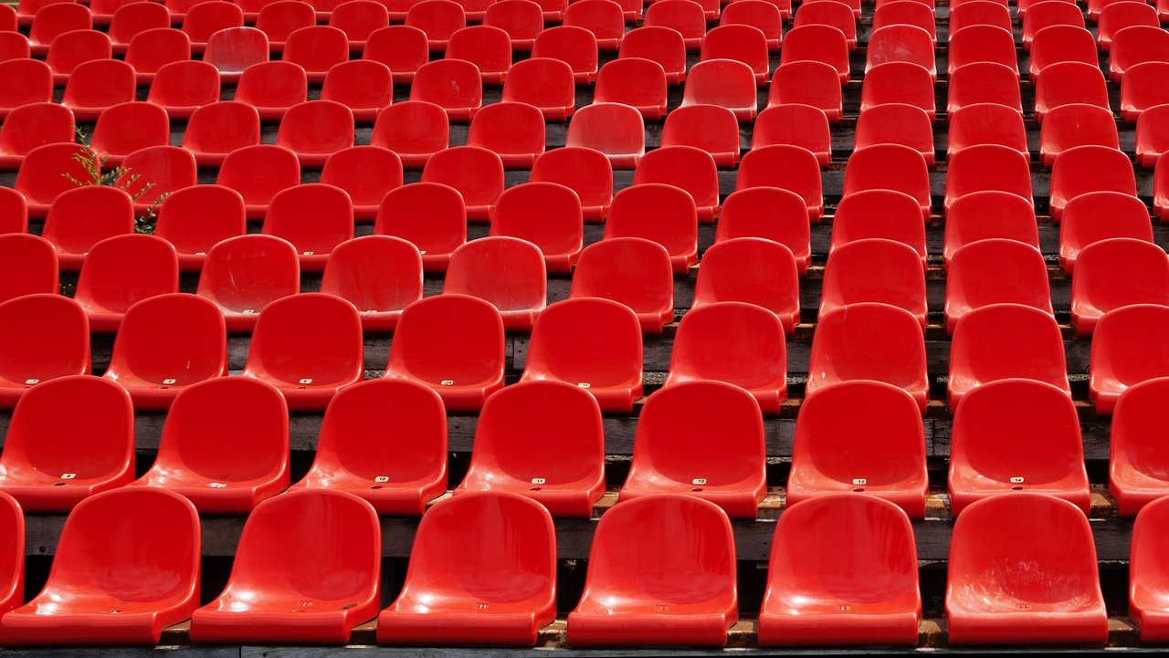 Man sieht viele rote Stadionsitze