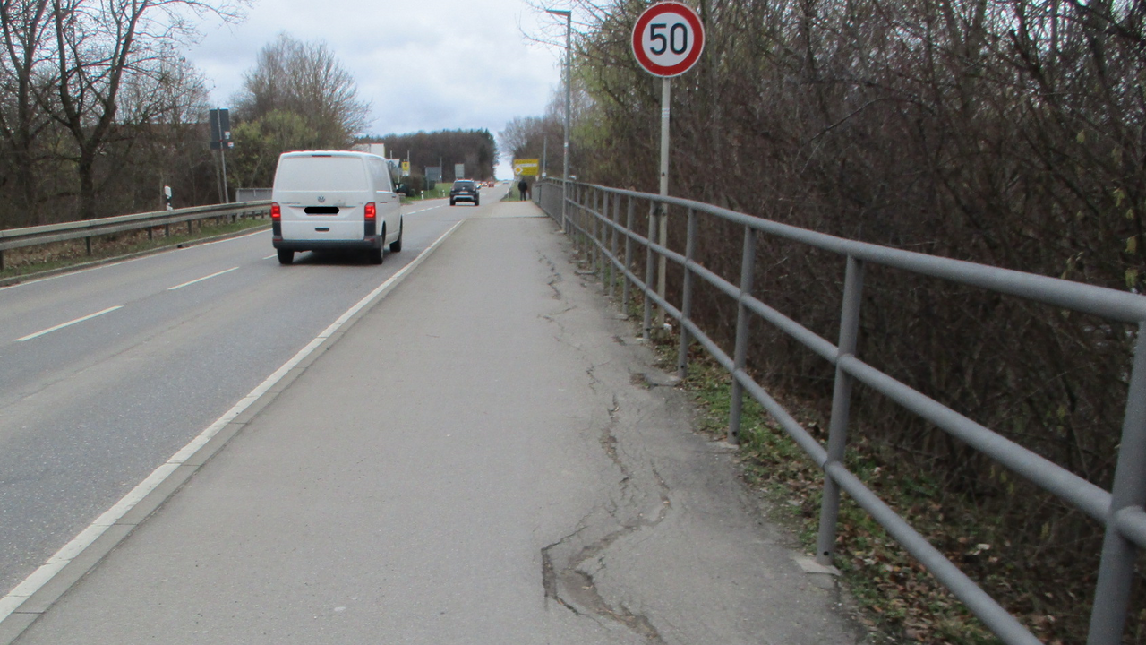 Das Bild zeigt die L 374 bei Riederich; Leitplanken, sanierungsbedürftiger Radweg, Fahrzeuge, Verkehrsschild
