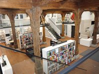 Blick von der Galerie ins Erdgeschoss mit Verbuchung und Kinderbereich in der Stadtbücherei im Kornhaus Wangen im Allgäu