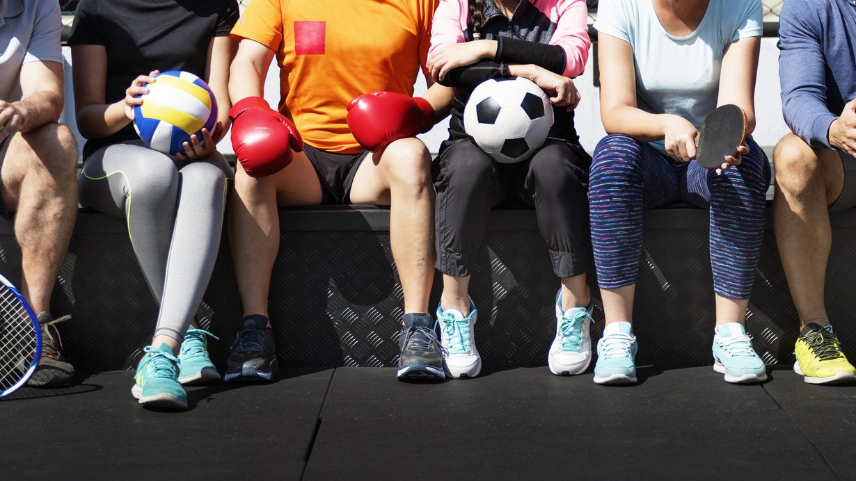 Sportler aus verschieden Sportarten sitzen beieinander