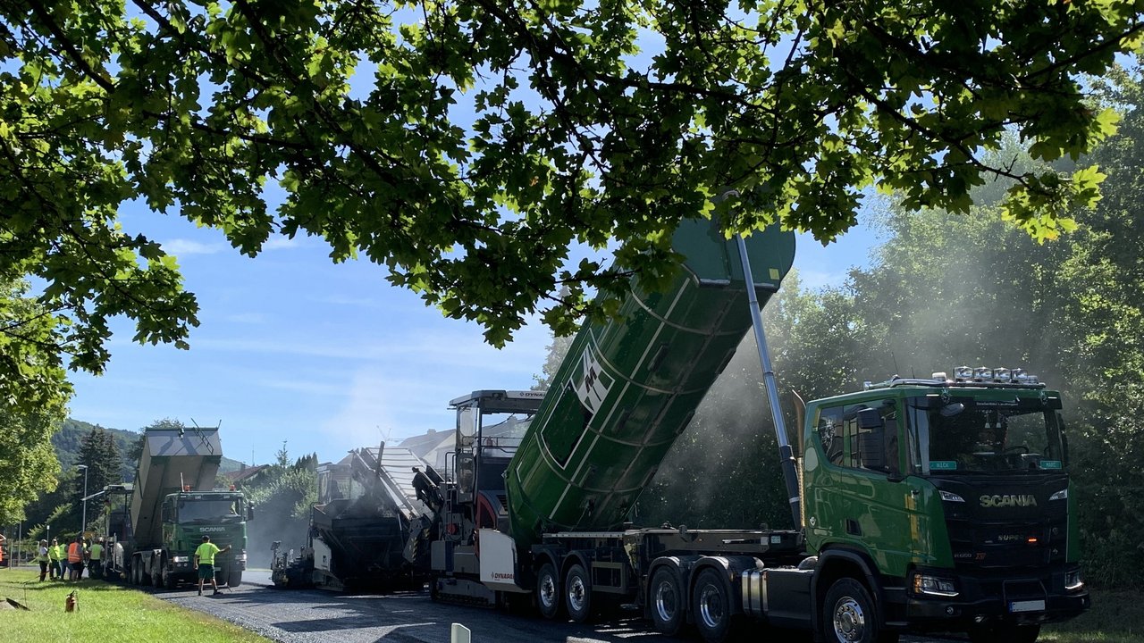 Das Bild zeigt Baustellenfahrzeuge mehrere Lastwagen die Baustellenmaterial auf die Baustelle kippen