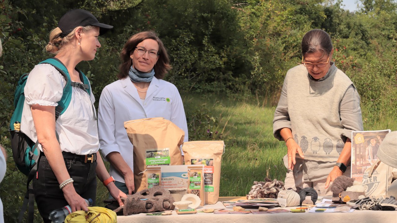 Ministerin Thekla Walker im Gespräch mit Lydia Steffan, Verein Biosphärengebiet Schwäbische Alb e.V., und Veronika Kraiser, Firma Flomax, über innovative Wollprodukte bei ihrem Besuch im Biosphärengebiet Schwäbische Alb Das Foto zeigt Ministerin Thekla Walker im Gespräch mit Lydia Steffan, Verein Biosphärengebiet Schwäbische Alb e.V., und Veronika Kraiser, Firma Flomax, über innovative Wollprodukte bei ihrem Besuch im Biosphärengebiet Schwäbische Alb