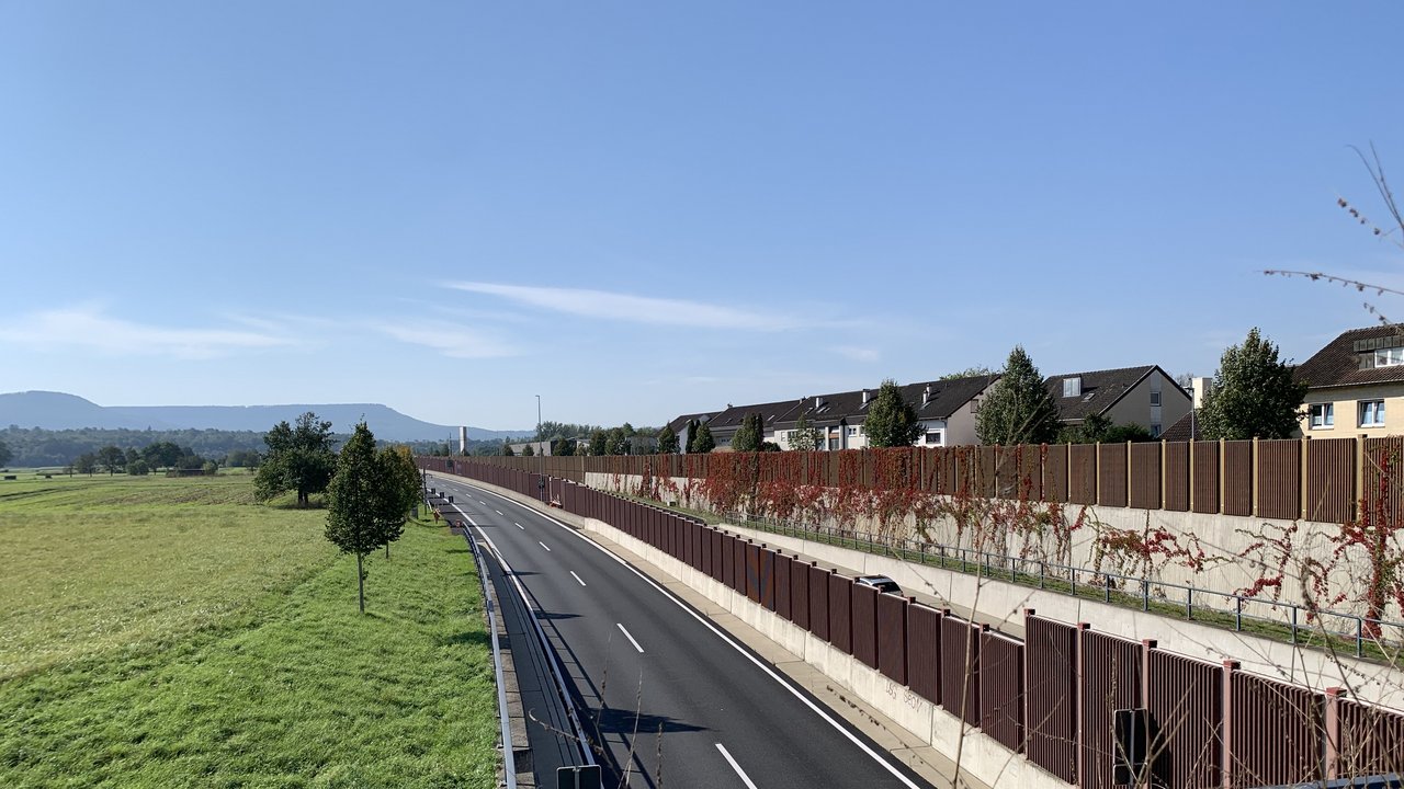 Das Foto zeigt die B27 vor der Einfahrt in den Tunnel Dusslingen; Schallschutzwände und Dusslingen sind rechts zu sehen