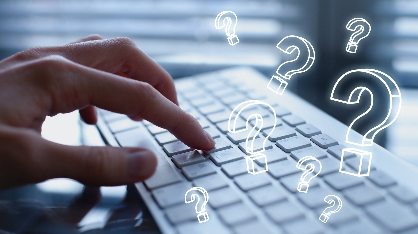 Finger auf einer Tastatur, im Vordergrund stilisierte Fragezeichen